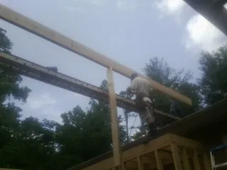Carpenter setting a ridge beam over a new addition frame — Ice Dam Removal by Roofing Brothers in Grand Prairie