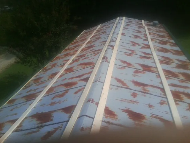 Rusted metal roof panels with new wood purlins before replacement — Storm Damage Roof Repair in Grand Prairie by Roofing Brothers