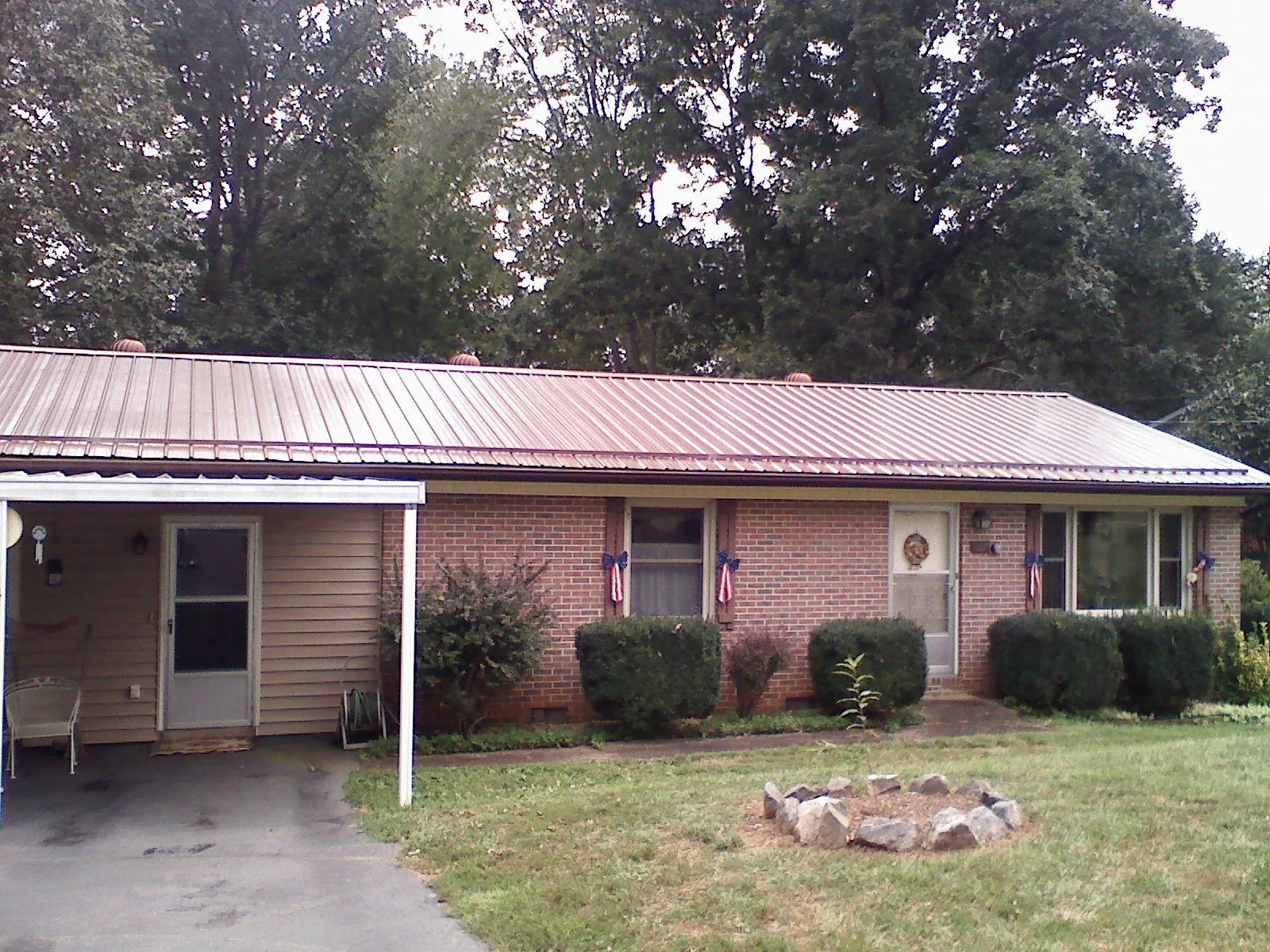 Bronze metal roof and carport on a brick ranch home — Roof Repair work by our crew in Grand Prairie
